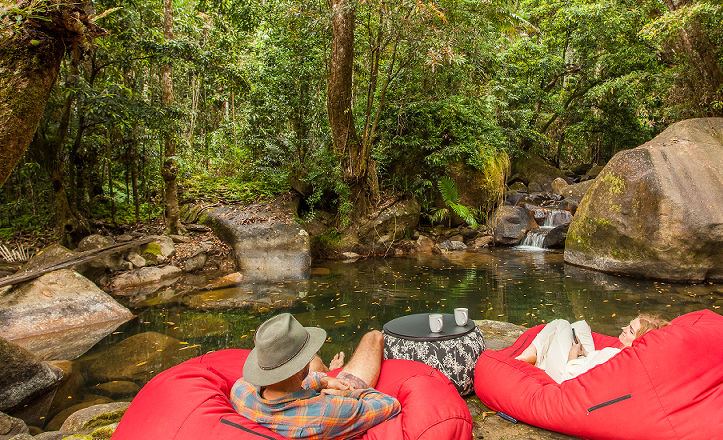 Guests enjoying an outdoor lunch next to the private natural freshwater swimming hole and waterfalls at Daintree Secrets