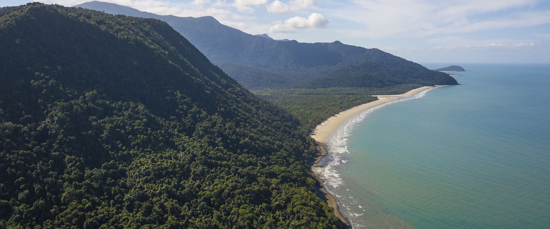 Breathtaking aerial drone view of Cape Tribulation coastal landscape where the tropical Daintree Rainforest meets the Coral Sea reef