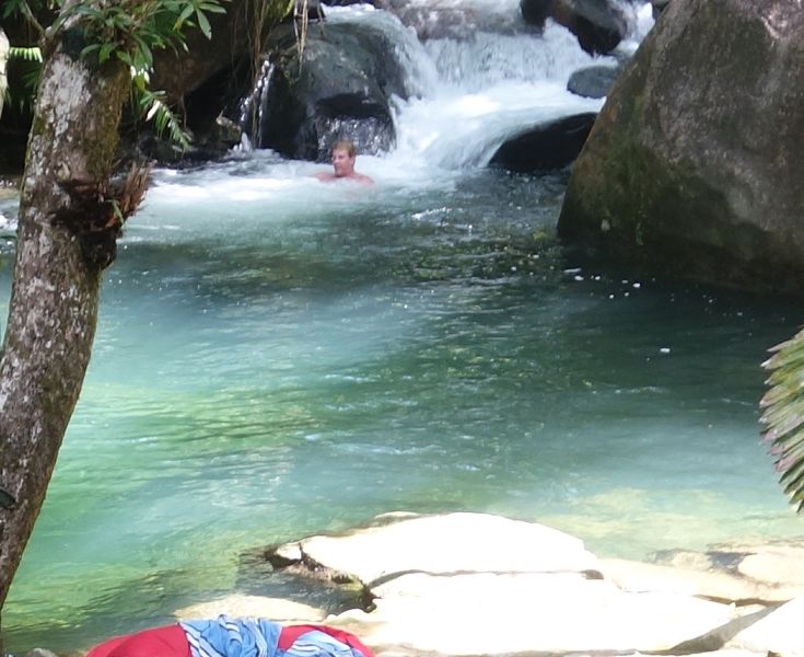 Swimmers enjoying the deep fifteen-meter wide crocodile-free freshwater swimming hole right off the timber deck
