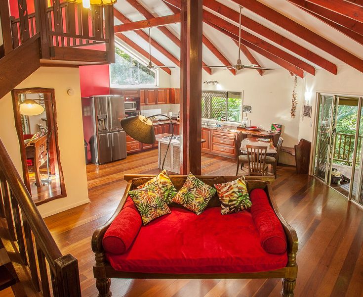 Modern open-plan living layout displaying the lounge, kitchen, and dining spaces leading out to the veranda