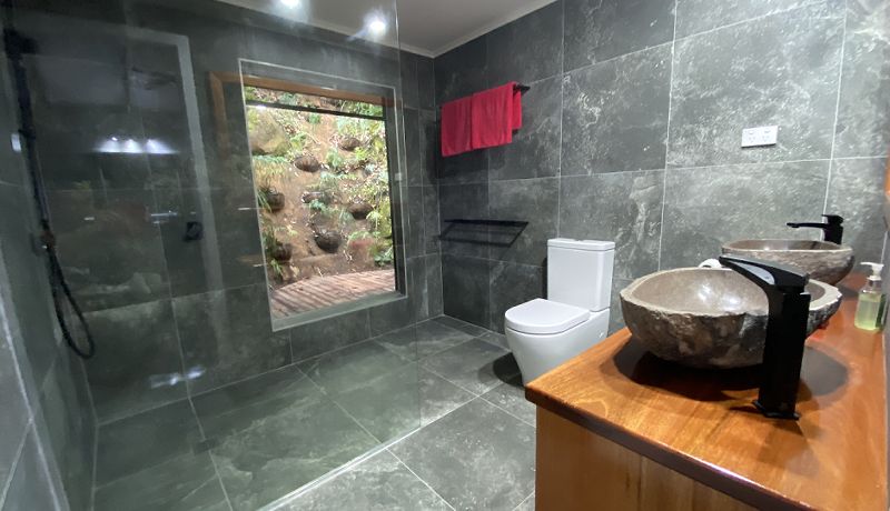 Beautifully renovated marble guest bathroom featuring a spacious walk-in shower area