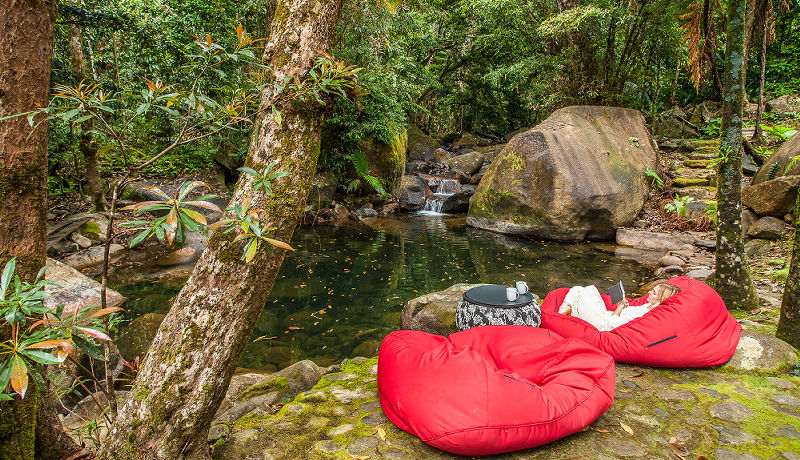 Guests swimming and enjoying the natural cascading waterfalls inside the private swimming hole