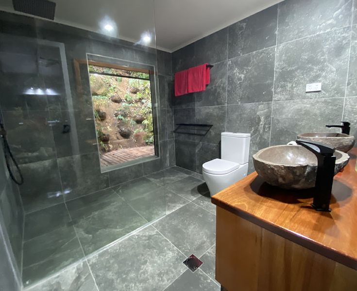 Beautifully renovated modern marble bathroom fitted with a spacious walk-in seamless glass shower enclosure